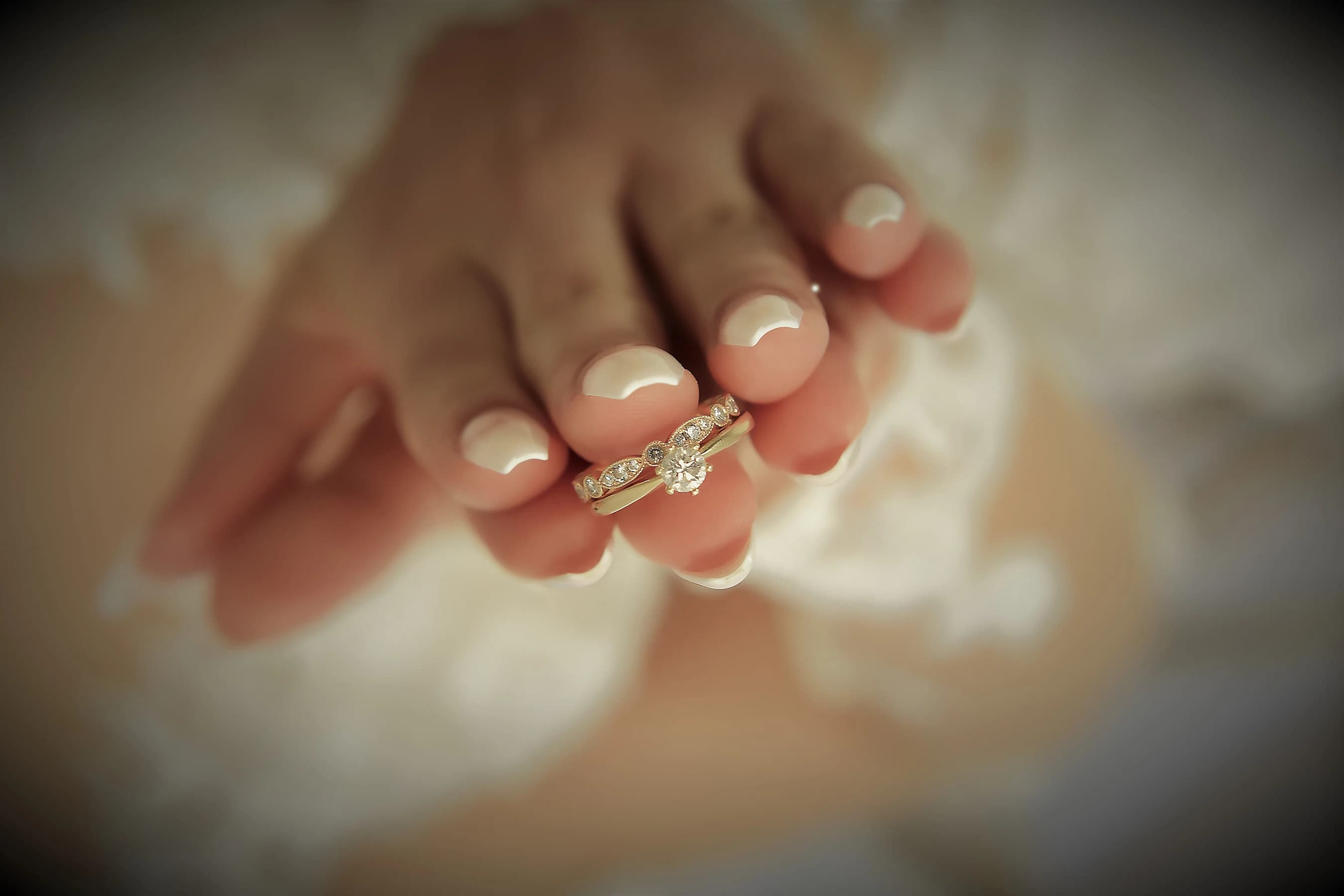 Kvinna som håller vigselring mellan händerna.